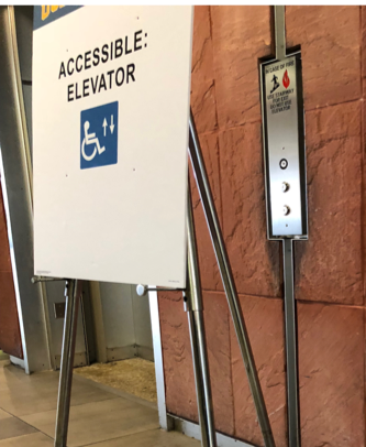 An "Accessible Elevator" sign blocking the elevator buttons
