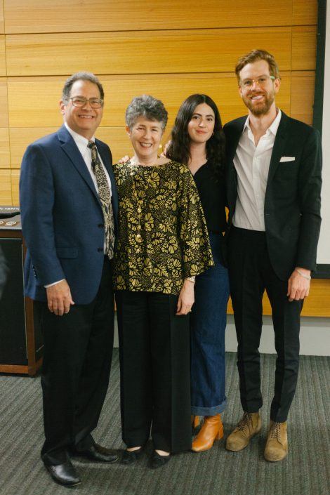 Two women and two men smile in front of camera.