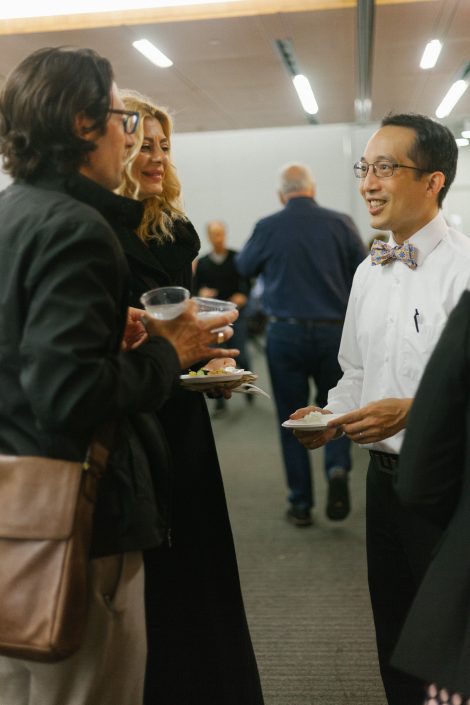Two women and a man share drinks together.