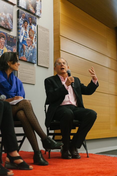Man holding a microphone gives a speech next to a woman.