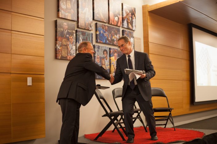 Two men shake hands.