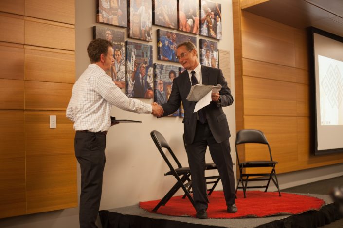 Two men shake hands.