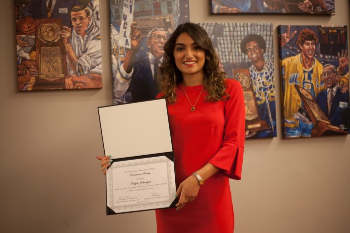 A woman holds up an award.