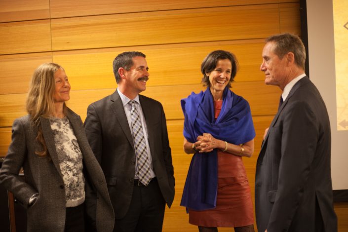 2 women and 2 men talk engage in conversation.