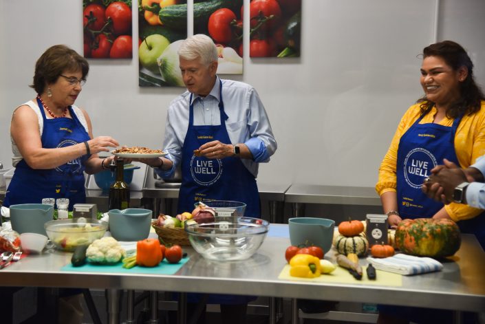 Man stands behind a pitching table with ingredients.