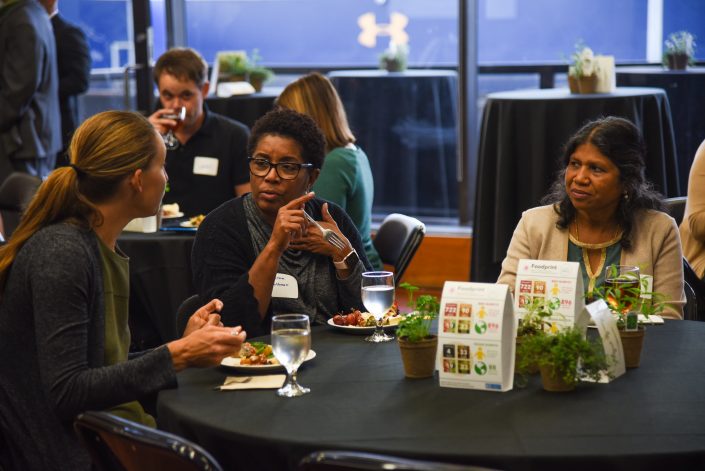 Women talk at a table.