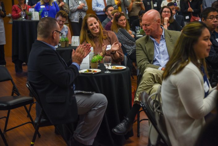 Table smiles while listening to speaker.