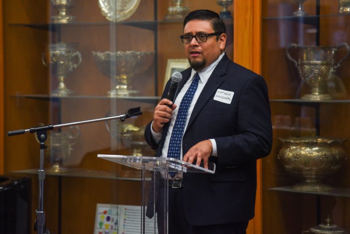 Man in suit speaks on stage.