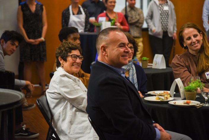 Woman and man smile from their seats.