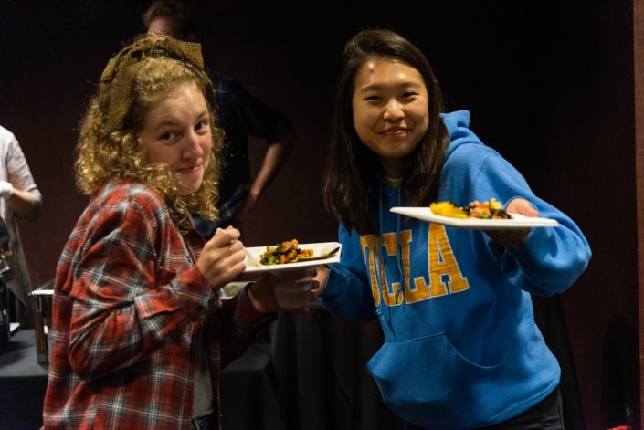 Two students smile at camera with their foods.