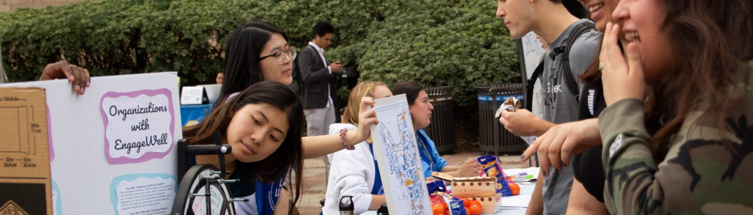 Woman with poster explains concepts to people.